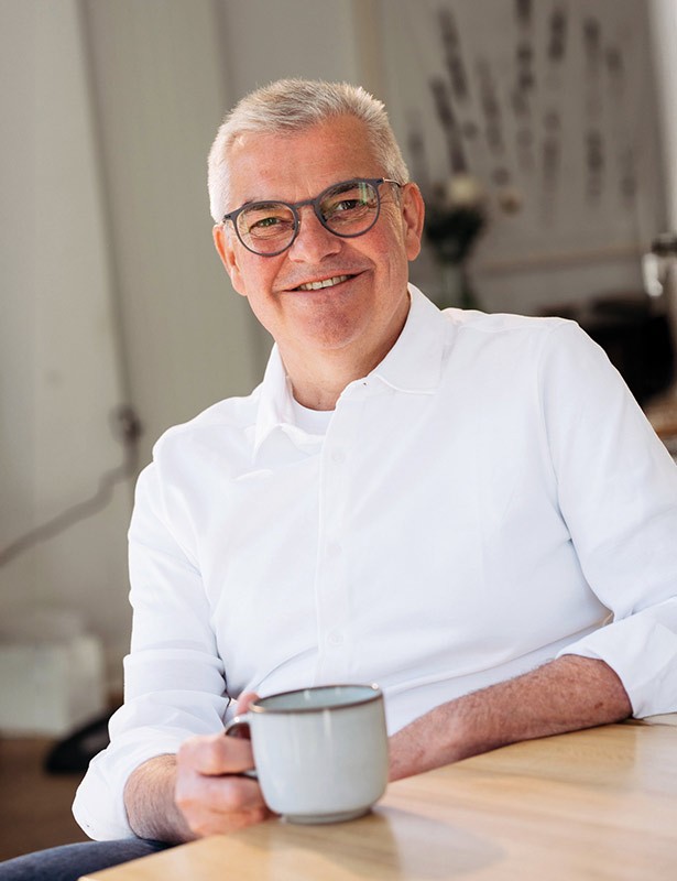 home-prokop-2colhoch Marc Prokop mit Kaffeetasse am Tisch sitzend